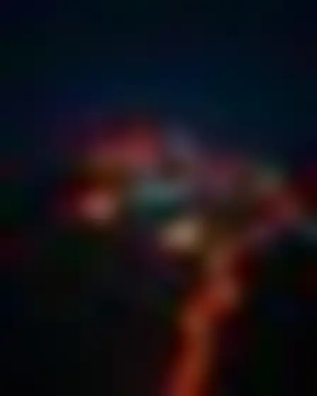 Copy-ready GPT Image prompt for a neon motion glow hillside village (editorial illustration). Blurred long-exposure neon glow in orange and electric blue with soft motion trails on a dark ground, with lighting, materials, camera, angle and composition details for a 4:3 image.