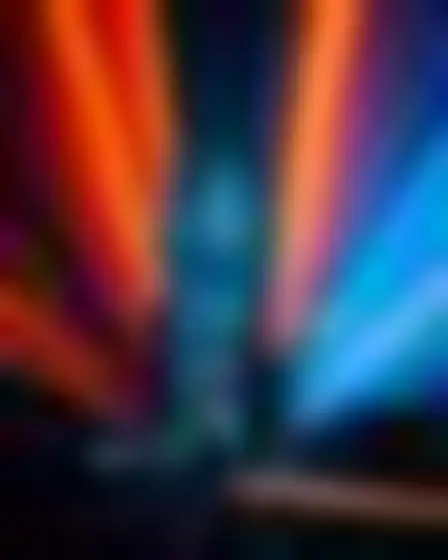 Conceptual Art AI image prompt for a neon motion glow city skyline: blurred long-exposure neon glow in orange and electric blue with soft motion trails on a dark ground. Written for GPT Image on a 4:3 canvas, with lighting, materials, lens, angle and composition direction included.