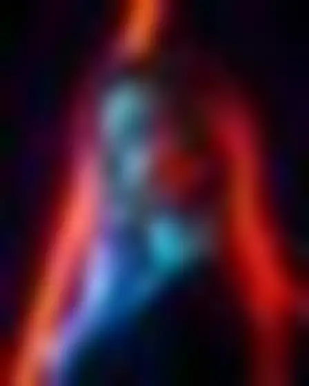 A professional editorial illustration prompt: neon motion glow woman in profile, blurred long-exposure neon glow in orange and electric blue with soft motion trails on a dark ground. Optimised for GPT Image on a 2:3 canvas.